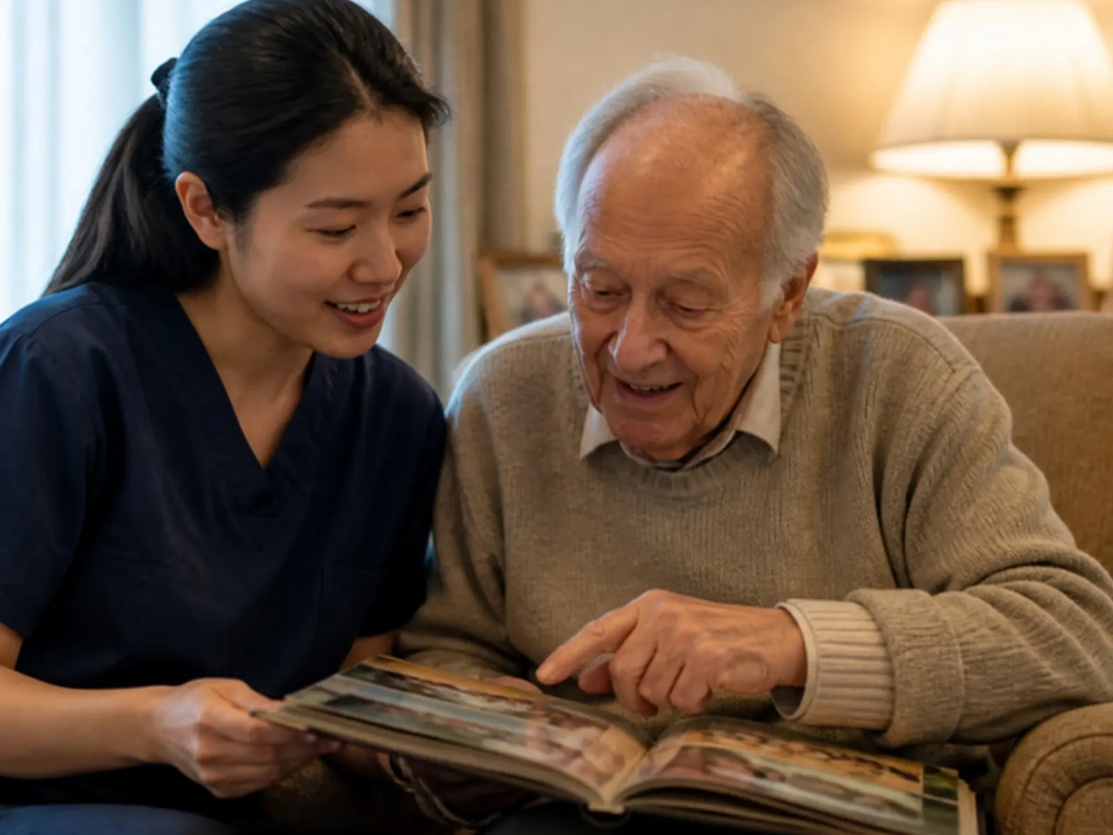 Caregiver sharing a family photo album with a man living with dementia during in-home memory care